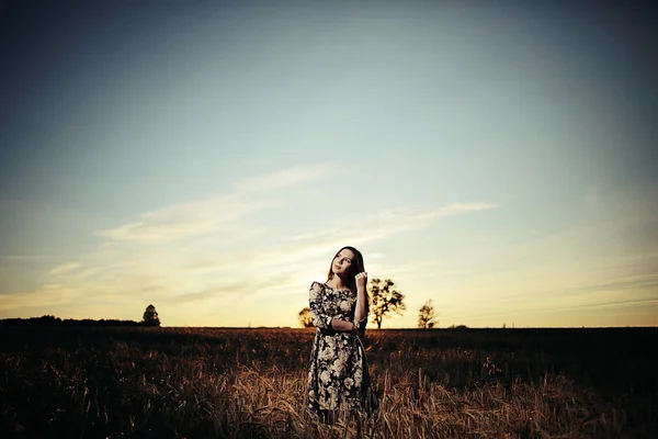 Flicka i fältet på himmel bakgrund — Stockfoto