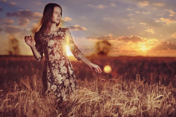 Meisje bij zonsondergang in veld — Stockfoto
