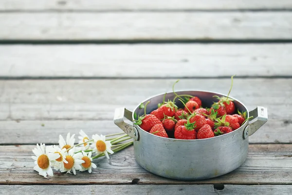 Skål med jordgubbar på bakgrund — Stockfoto