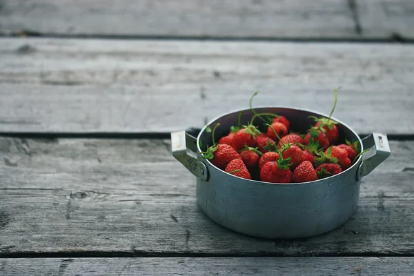 Skål med jordgubbar på bakgrund — Stockfoto