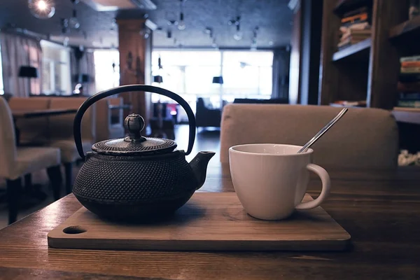 Tetera y taza de té en un café —  Fotos de Stock