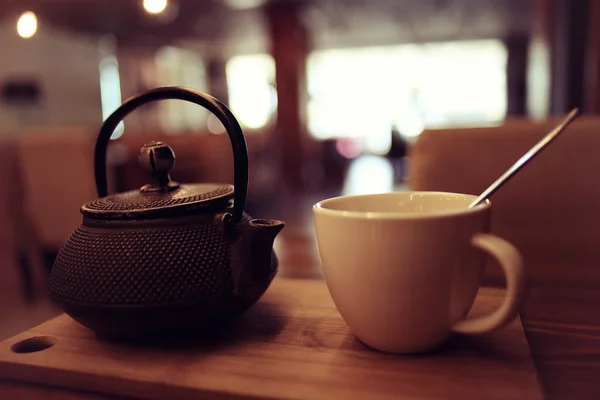 Teáskanna és egy csésze tea egy kávézóban — Stock Fotó