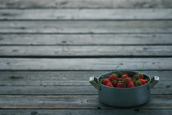 Skål med jordgubbar på bakgrund — Stockfoto