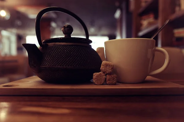 Teáskanna és egy csésze tea egy kávézóban — Stock Fotó
