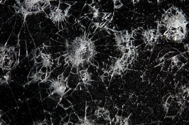 Siyah cam arka plandaki çatlaklar, kırık cam delik yok etme kavramı.