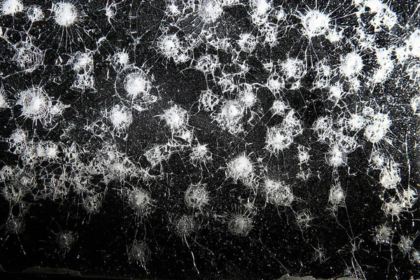 Siyah cam arka plandaki çatlaklar, kırık cam delik yok etme kavramı.