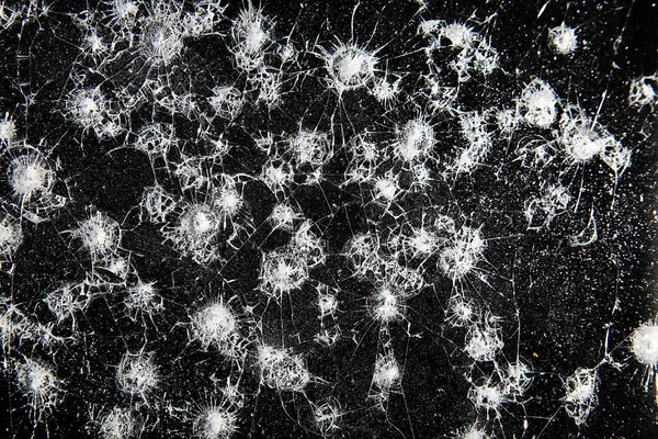 Siyah cam arka plandaki çatlaklar, kırık cam delik yok etme kavramı.