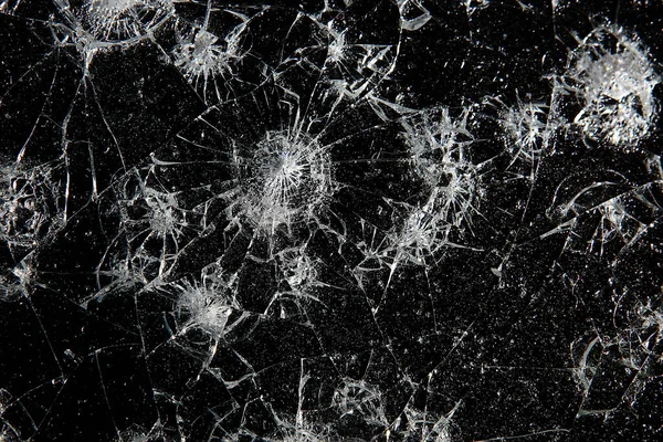 Siyah cam arka plandaki çatlaklar, kırık cam delik yok etme kavramı.