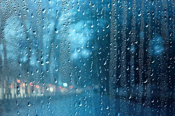 Dalların ıslak cam manzarası sonbaharda park yeri, soyut arkaplan damlaları Kasım akşamında pencere kenarında