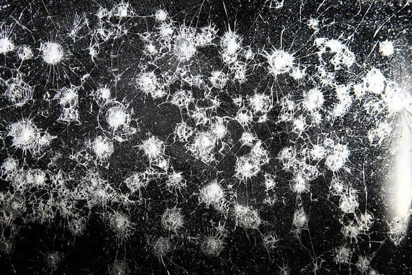 Siyah cam arka plandaki çatlaklar, kırık cam delik yok etme kavramı.