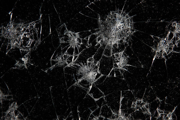 cracks on black glass background, broken abstract glass hole destruction concept