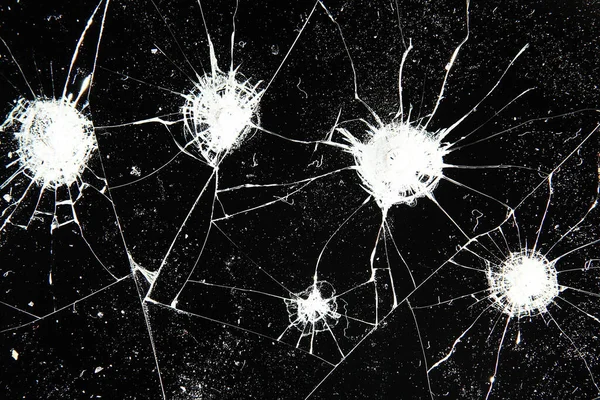 Siyah cam arka plandaki çatlaklar, kırık cam delik yok etme kavramı.