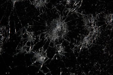 Siyah cam arka plandaki çatlaklar, kırık cam delik yok etme kavramı.