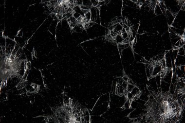 Siyah cam arka plandaki çatlaklar, kırık cam delik yok etme kavramı.