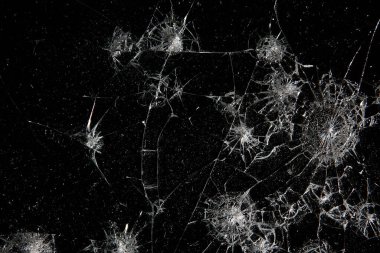 Siyah cam arka plandaki çatlaklar, kırık cam delik yok etme kavramı.