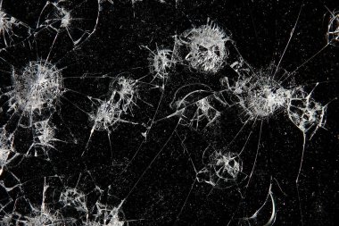 Siyah cam arka plandaki çatlaklar, kırık cam delik yok etme kavramı.