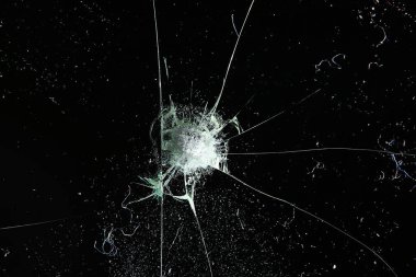 Siyah cam arka plandaki çatlaklar, kırık cam delik yok etme kavramı.