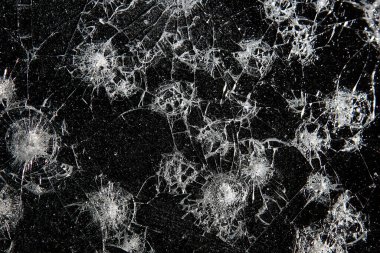 Siyah cam arka plandaki çatlaklar, kırık cam delik yok etme kavramı.