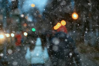 Soyut kar arka planda bulanık şehir ışıkları, kış tatili yeni yıl