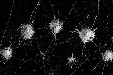 Siyah cam arka plandaki çatlaklar, kırık cam delik yok etme kavramı.