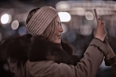 Dışarıda telefonlu genç bir model var.