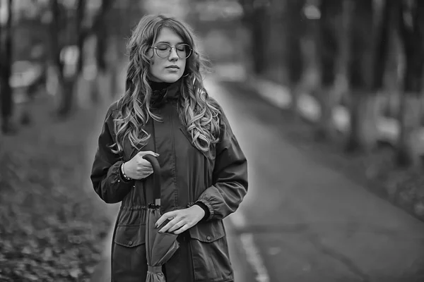 seasonal autumn portrait, sad girl with umbrella, november seasonal virus immunity on a walk