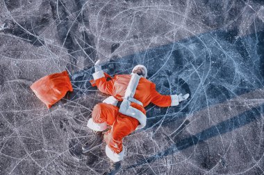 Noel Baba gölün buzunda kayıyor, kayıyor, yatıyor, Noel Baba eziği.