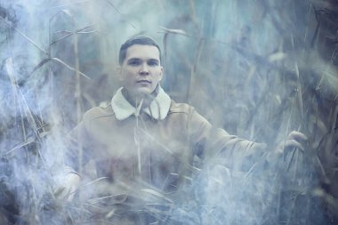 Sonbahar tarzı portrede poz veren şık genç adam, hipster doğa seyahati.