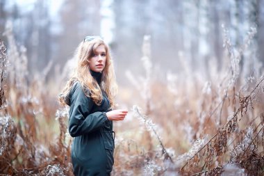 Parkta sonbaharın sonlarında, Avrupa tarzı çekici görünümlü yetişkin bir kız.