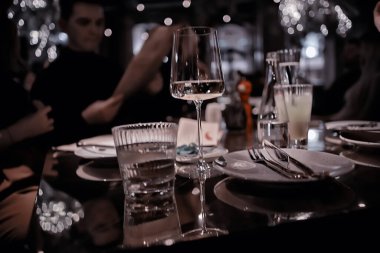 Restoran masası manzarası akşam şarap bardağı, partideki arkadaşlar.