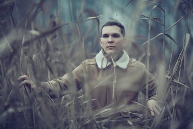 Sonbahar tarzı portrede poz veren şık genç adam, hipster doğa seyahati.