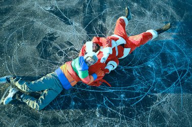 Adam Noel Baba 'dan hediyeler alıyor, gölün buzunda kayıyor, Noel Baba' yı soyuyor.