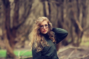 Parkta sonbaharın sonlarında, Avrupa tarzı çekici görünümlü yetişkin bir kız.