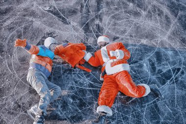 Adam Noel Baba 'dan hediyeler alıyor, gölün buzunda kayıyor, Noel Baba' yı soyuyor.