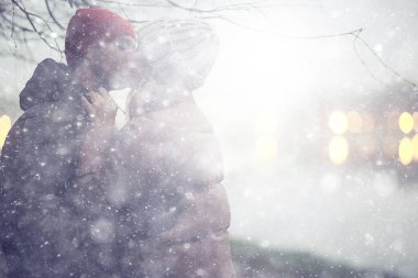 Birbirine aşık çiftler kış akşamı dışarıda sarılıyorlar, mevsimsel soyut arka plan, alacakaranlık yağmuru