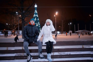 Buz pateni pistinde bir çift, Aşıklar kış tatilinde spor yapıyor.