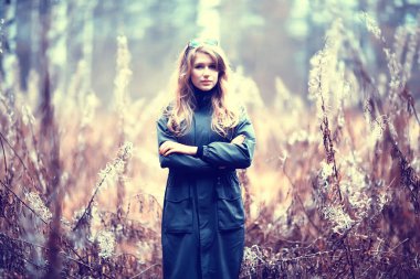 Parkta sonbaharın sonlarında, Avrupa tarzı çekici görünümlü yetişkin bir kız.