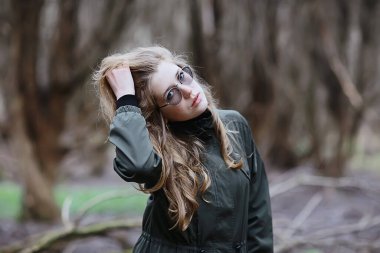 Parkta sonbaharın sonlarında, Avrupa tarzı çekici görünümlü yetişkin bir kız.