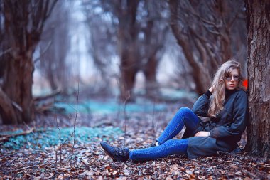 Parkta sonbaharın sonlarında, Avrupa tarzı çekici görünümlü yetişkin bir kız.