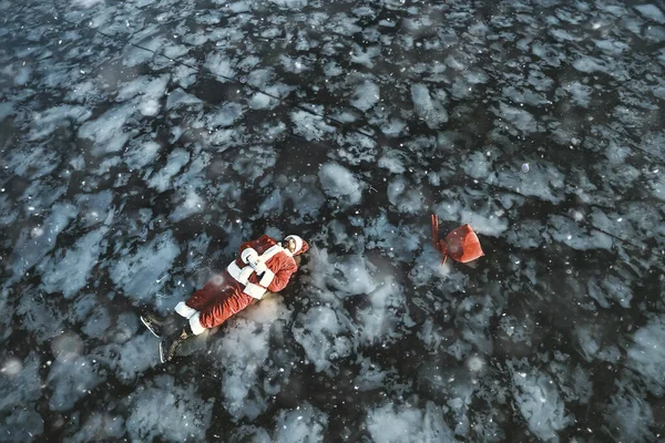 サンタクロースは湖の氷の上でスケート 横になり サンタ負け犬 — ストック写真