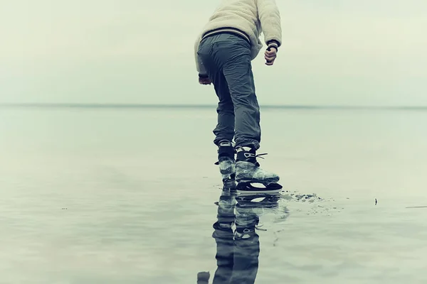 one guy skates on the ice of a frozen lake, nature landscape, man outdoor sports