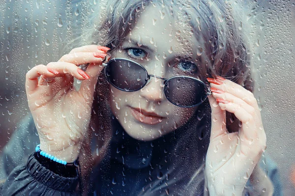 季節の秋の携帯電話濡れたガラスの後ろの悲しい女の子雨滴の背景 — ストック写真