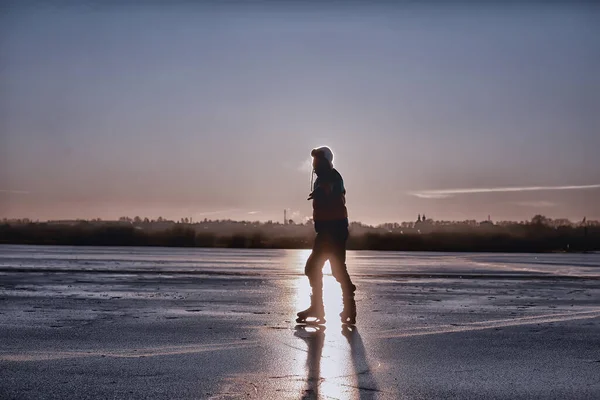 one guy skates on the ice of a frozen lake, nature landscape, man outdoor sports