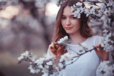 Mutlu kız çiçek açan bir bahçede rüya görüyor, taze şefkat dolu bahar kadını çiçekler içinde.