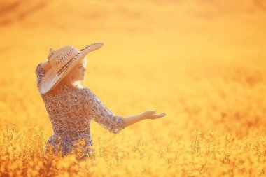 Çekici, aktif, güzel bir kadın, özgürce arkadan mutlu bir manzara, bir çiçek tarlasında.