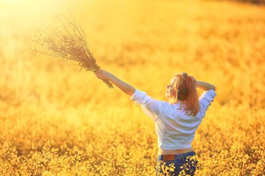 Kulaklıklı bir kızın çiçek tarlasında müzik dinlemesi, bahar müziği mutludur.