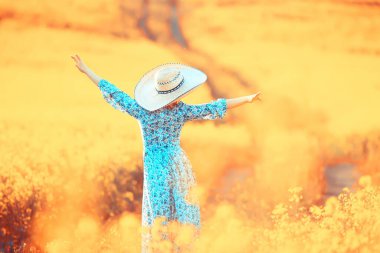 Çekici, aktif, güzel bir kadın, özgürce arkadan mutlu bir manzara, bir çiçek tarlasında.