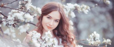 Bahar zamanı kiraz bahçesindeki genç bir kızın moda portresi, sabahın şefkati.