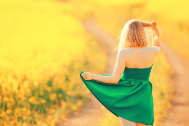 Bahar doğası. Çiçek tarlasında genç bir kız. Güneşli bir manzarada bir bayanın özgürlüğü ve mutluluğu.