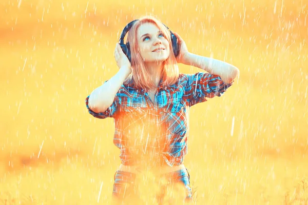 girl with headphones listening to music in summer rain outside summertime music